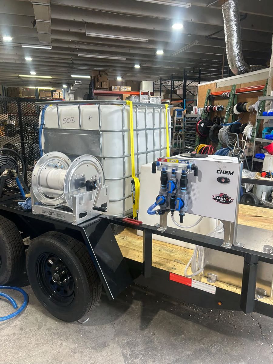 Side of the rig: hose reel, water tank strapped in, and the chemical panel with SH, soap and water lines